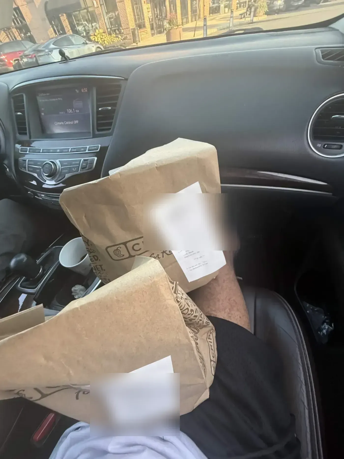 Chipotle pickup bags with receipts on the passenger seat of a car